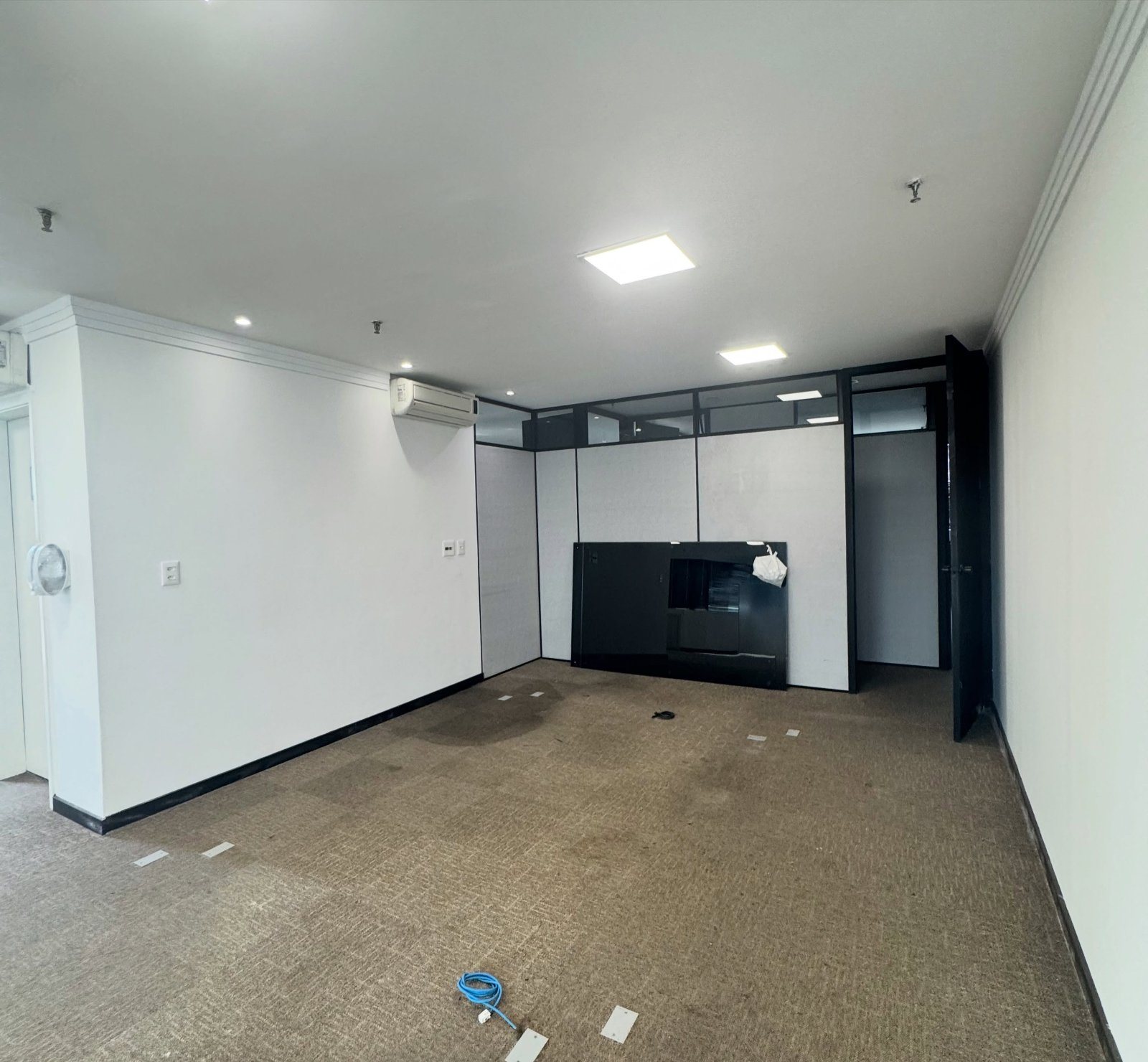 Escritório antes da consultoria: sala vazia com forro branco e divisórias de vidro