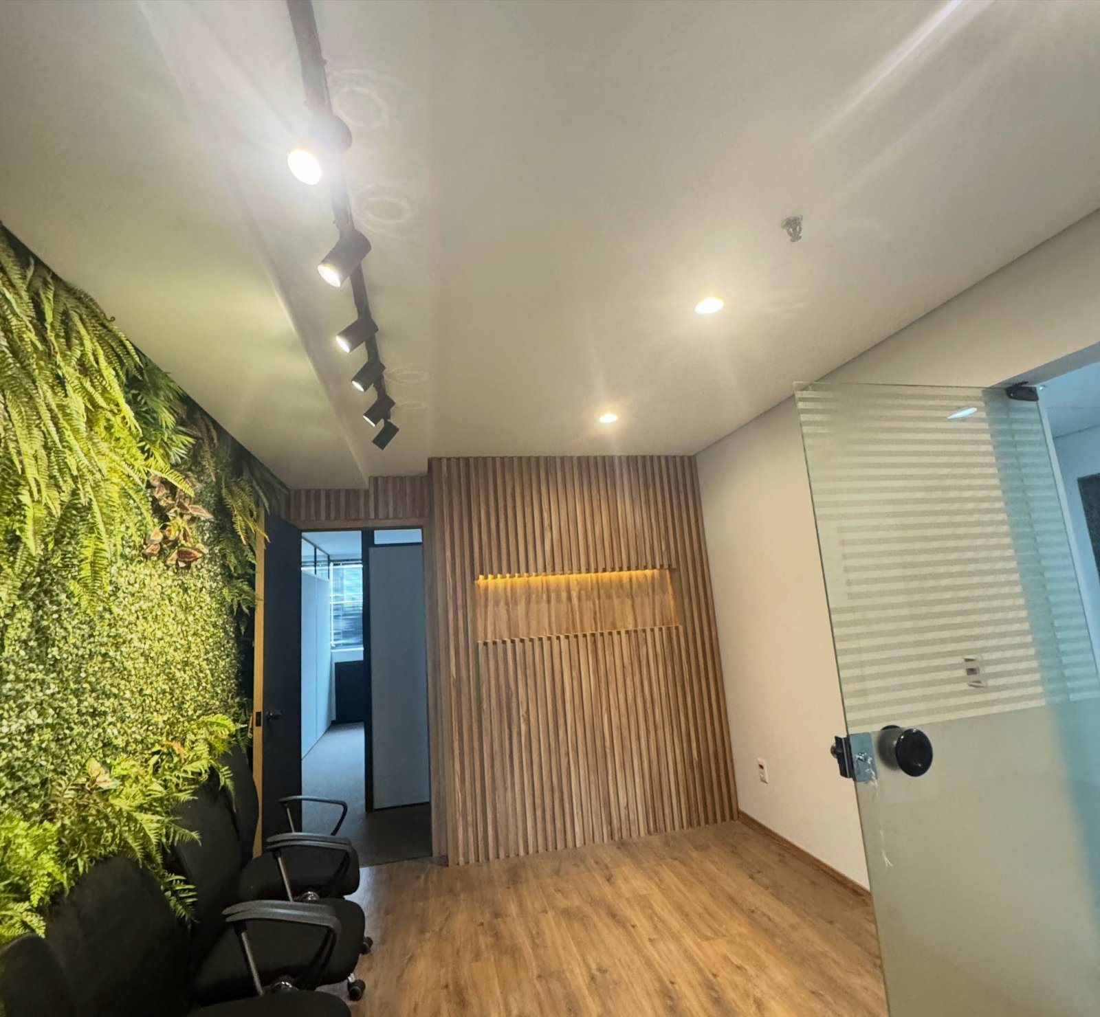 Depois: corredor com jardim vertical e painel ripado